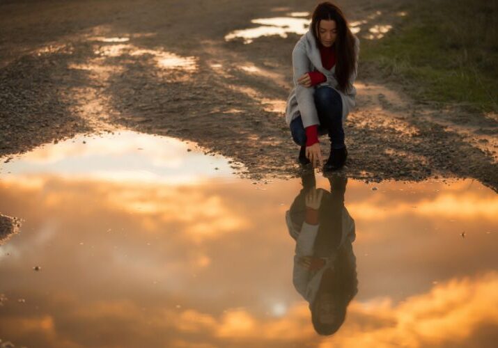 woman sees reflection in lake